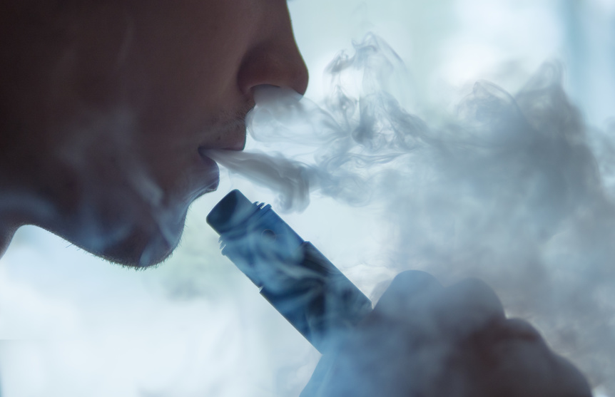 Person atmet Dampf einer E-Zigarette aus